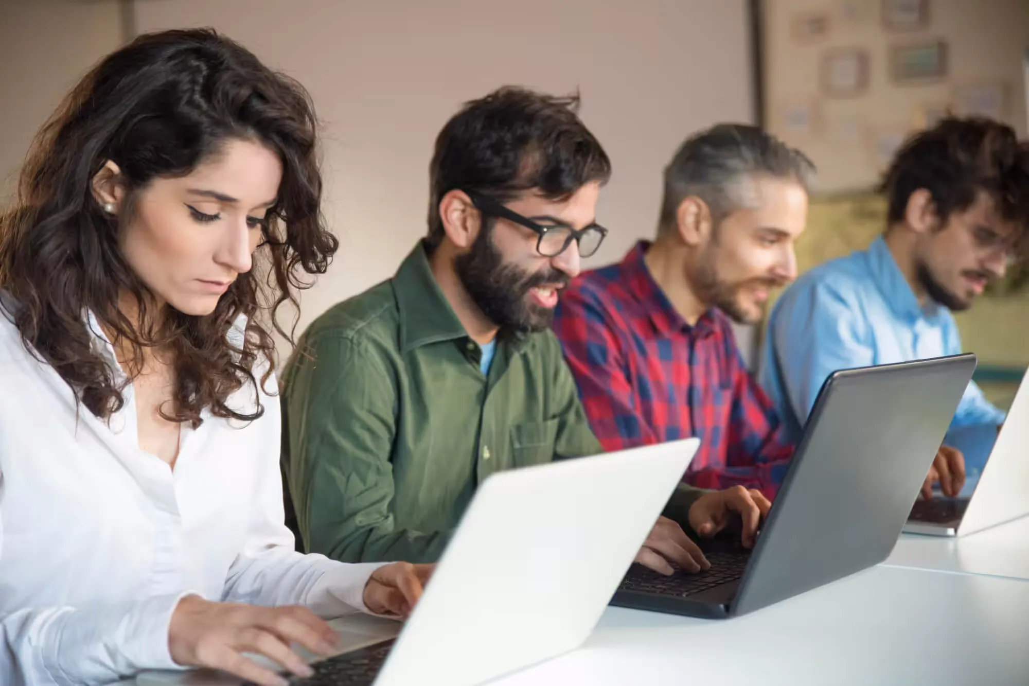 focused coworkers using laptops meeting table